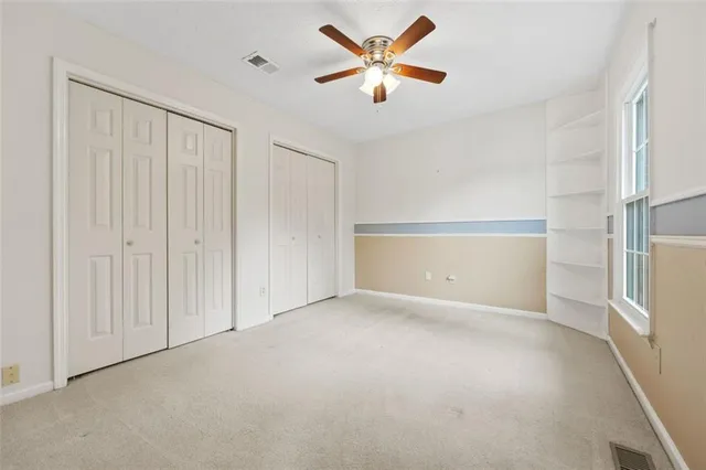 an empty room with closet and windows
