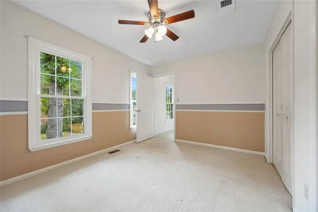 an empty room with windows and closet