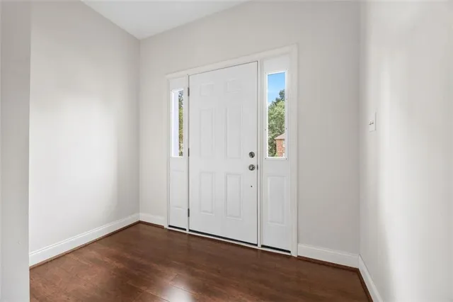 a view of an empty room with wooden floor