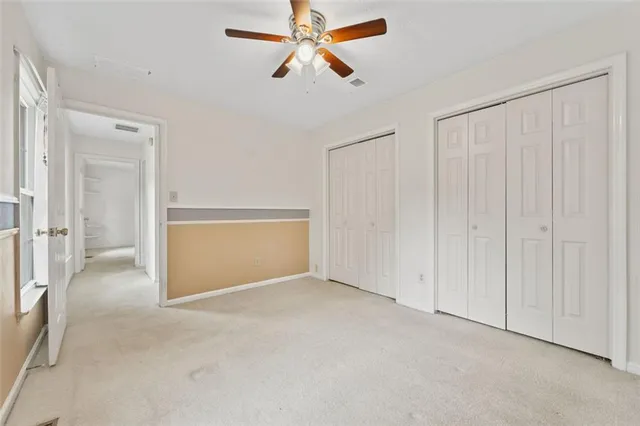 an empty room with chandelier fan