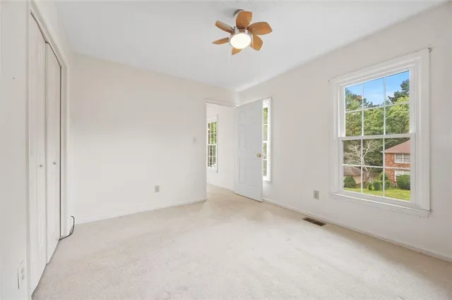 an empty room with a window and a ceiling fan