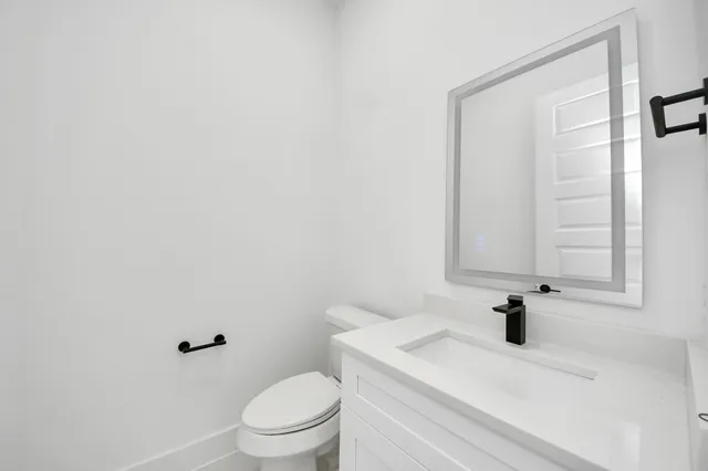 a bathroom with a sink a toilet and a mirror