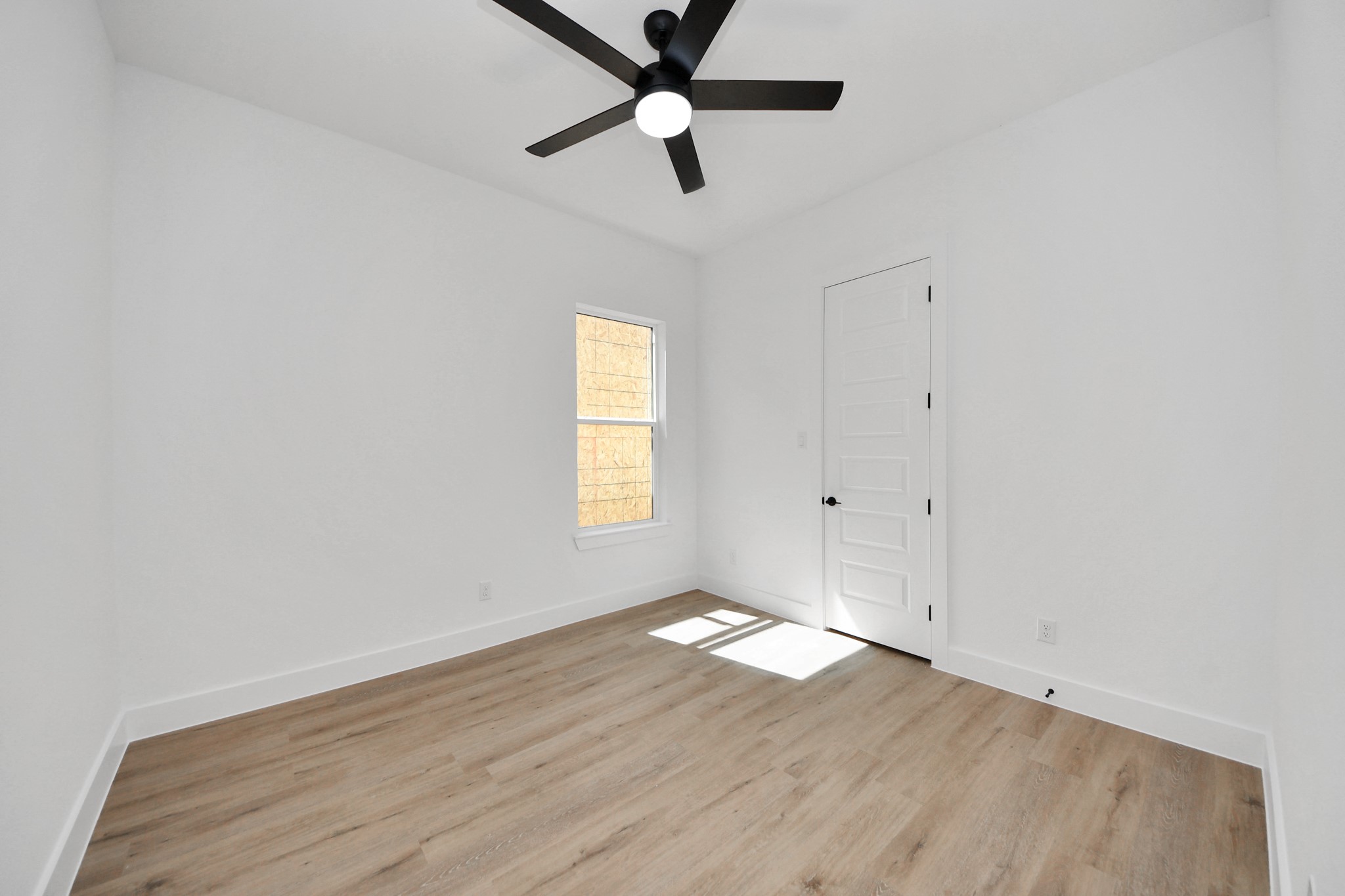 3310 Hardy Street Houston, TX 77009 - Photo 23 of 26 an empty room with wooden floor ceiling fan and windows