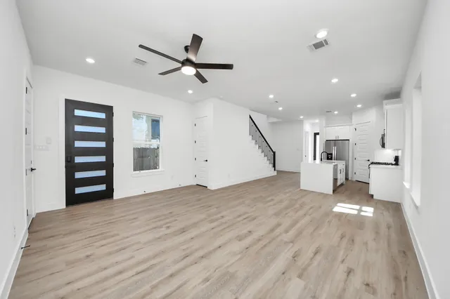 a view of empty room with wooden floor and window