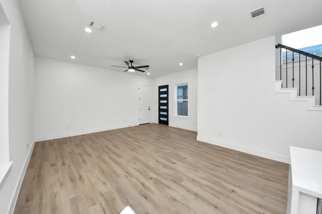 a view of empty room with wooden floor