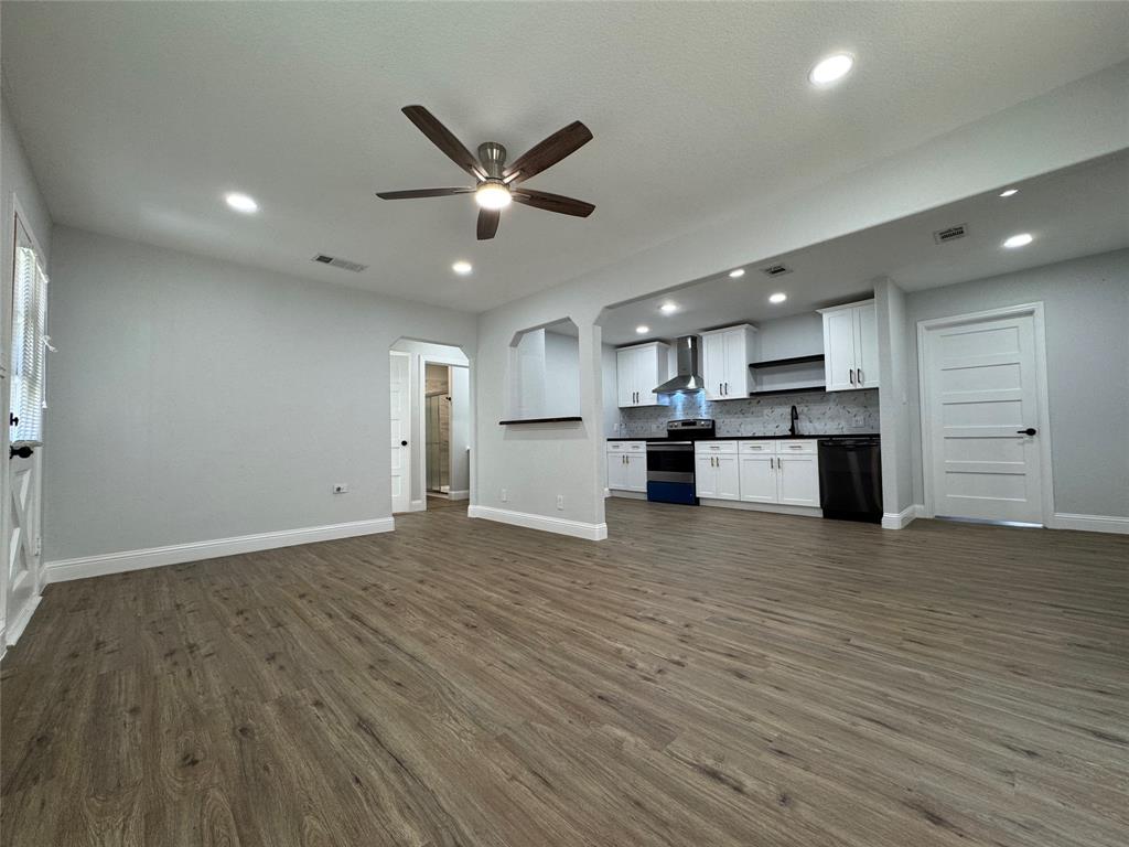 2909 Alexander Avenue Waco, TX 76708 - Photo 9 of 27 Unfurnished living room with arched walkways, ceiling fan, dark wood-style floors, and recessed lighting
