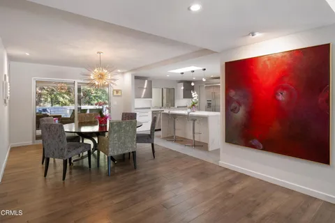 a dining room filled chandelier and wooden floor
