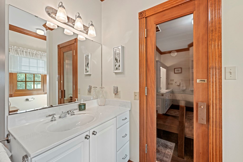 726 Paradise Ranch Road Fredericksburg, TX 78624 - Photo 16 of 38 a en suite bathroom with a sink a mirror a vanity and a shower