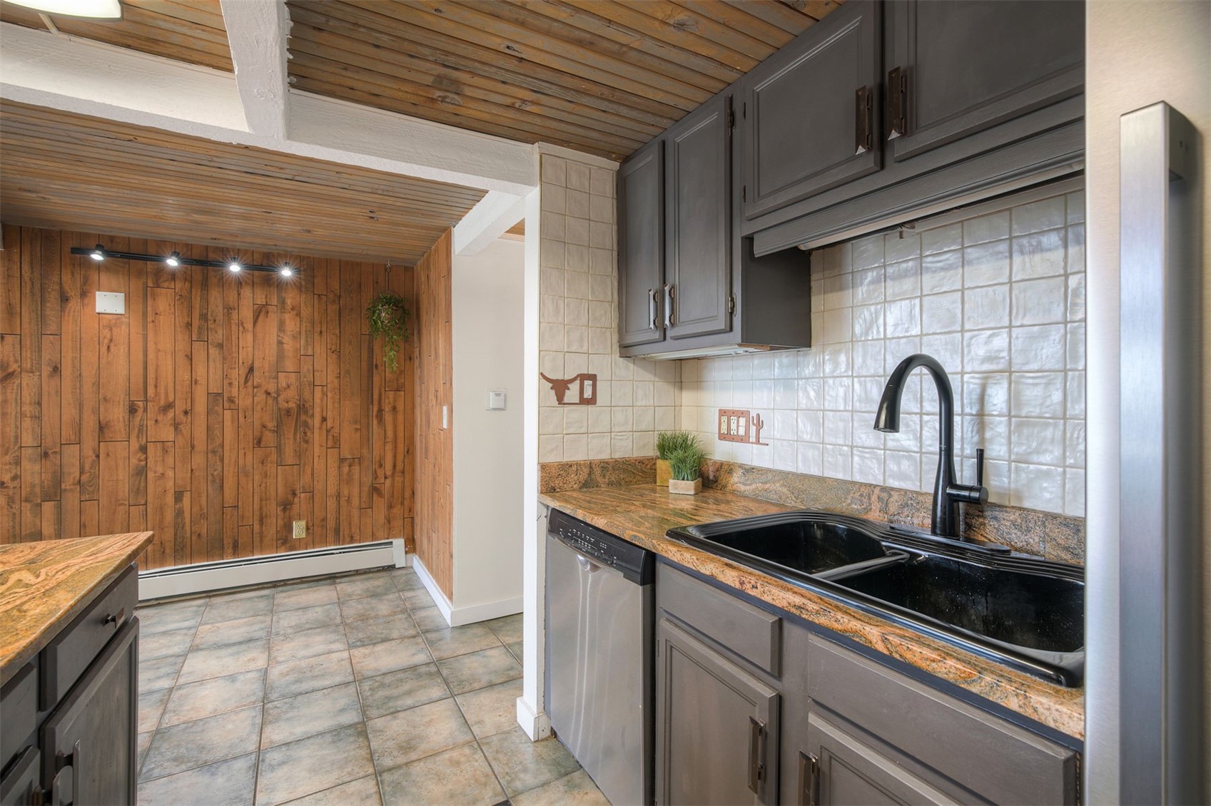7031 Ryan Gulch Road, Unit 301 Silverthorne, CO 80498 - Photo 9 of 37 a kitchen with granite countertop a sink and cabinets