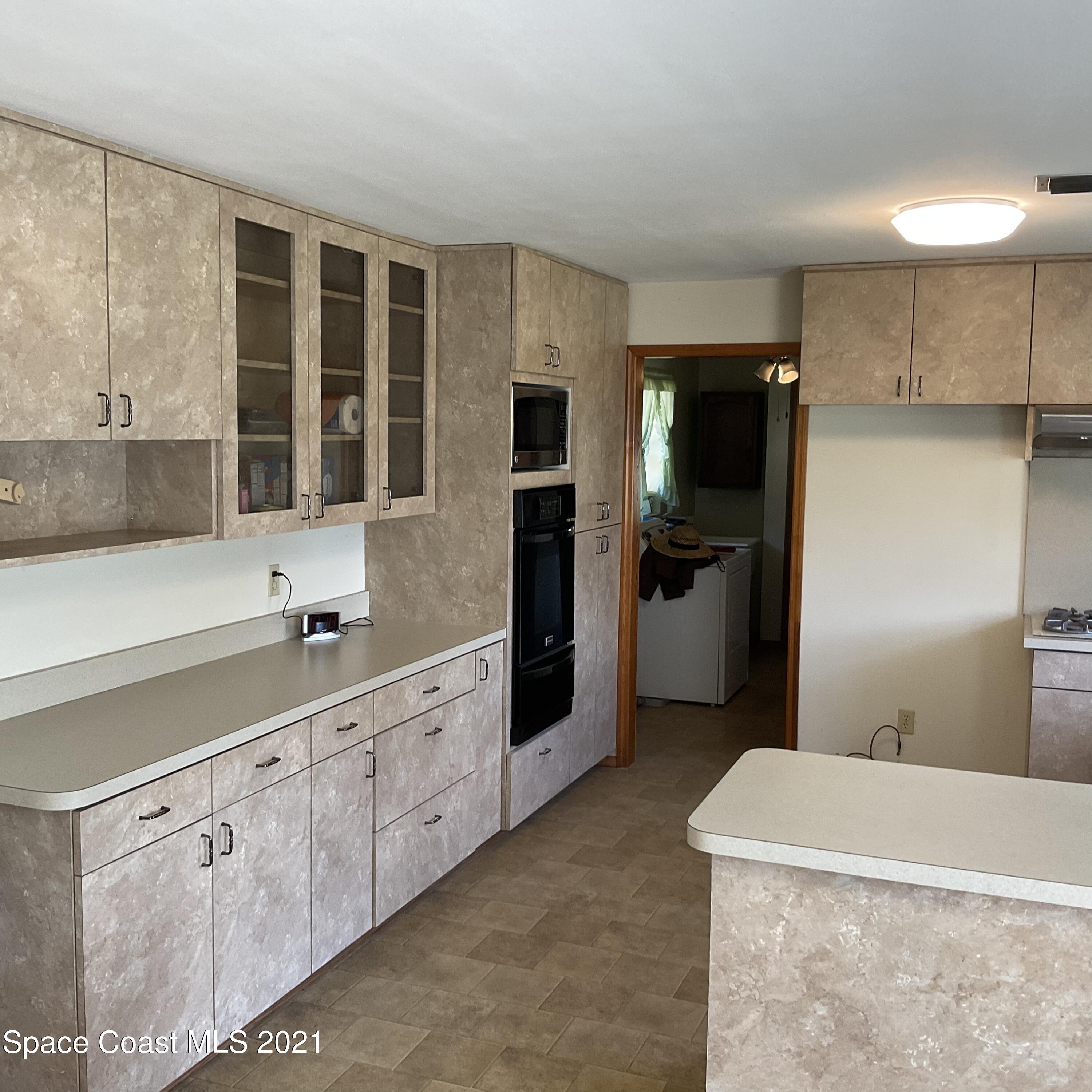 2580 Tammy Drive Mims, FL 32754 - Photo 21 of 47 a large kitchen with cabinets and stainless steel appliances