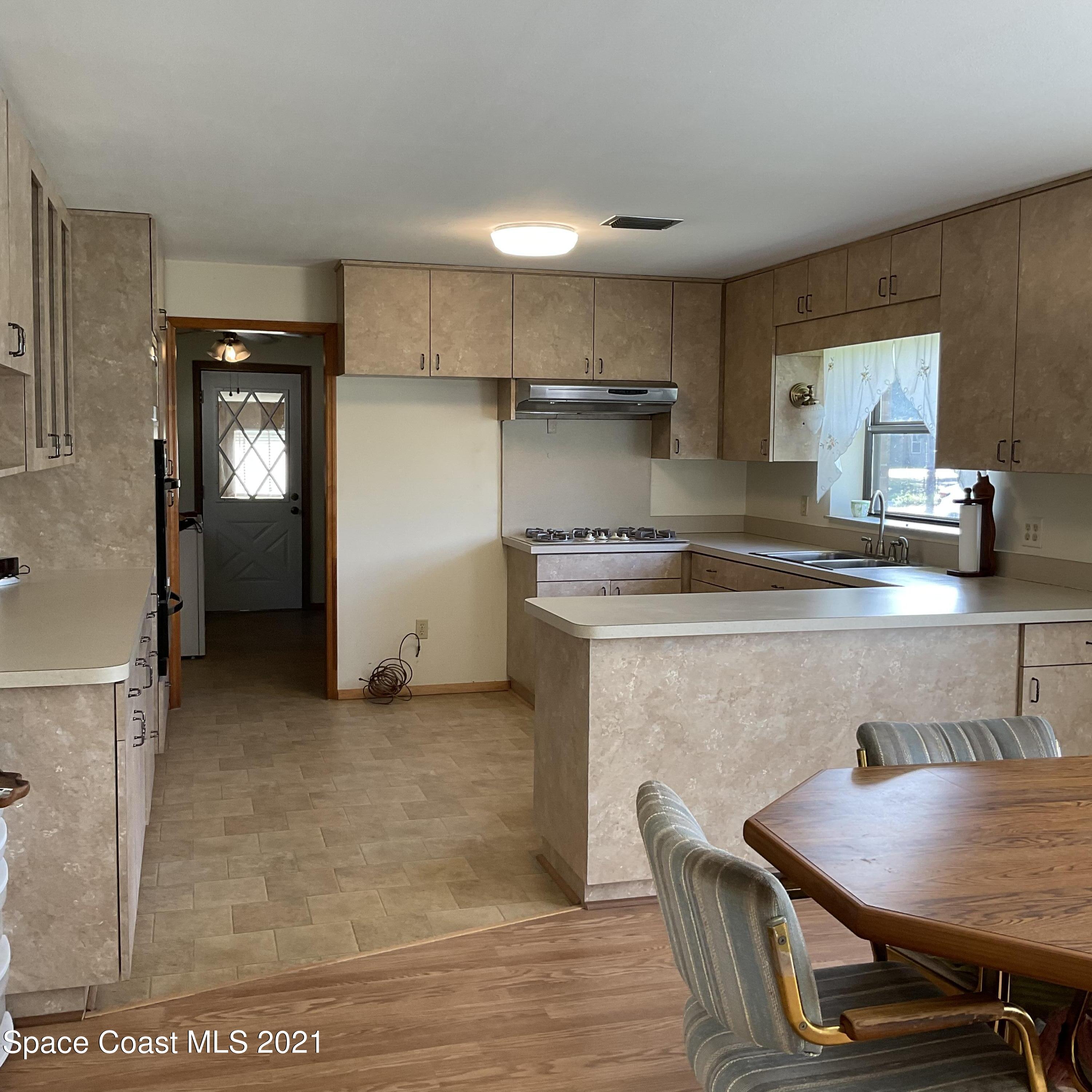 2580 Tammy Drive Mims, FL 32754 - Photo 4 of 47 a kitchen with kitchen island a table and chairs in it