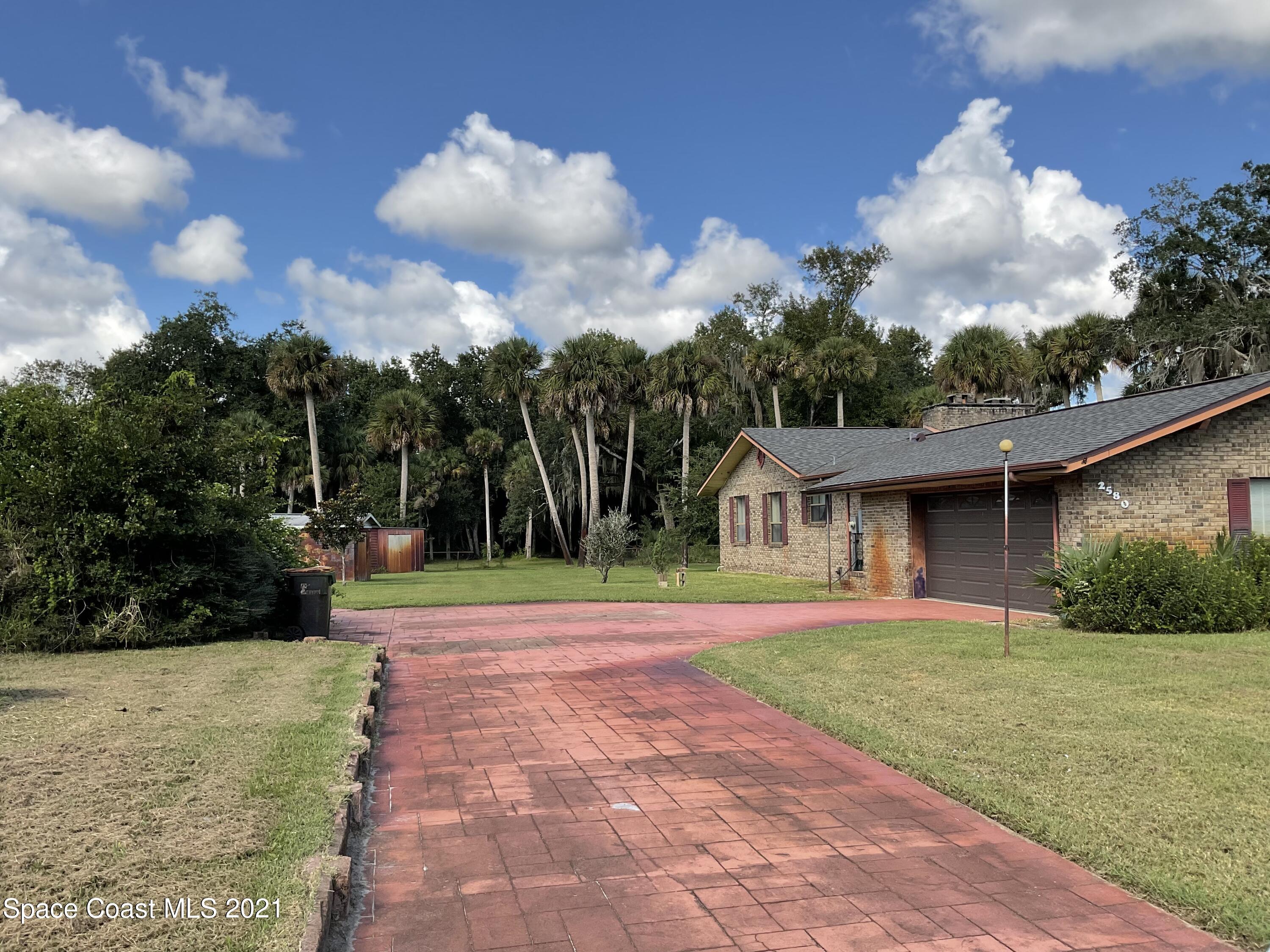 2580 Tammy Drive Mims, FL 32754 - Photo 42 of 47 a front view of a house with a yard and trees