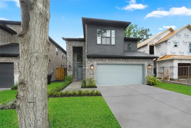 a front view of a house with a garden and yard