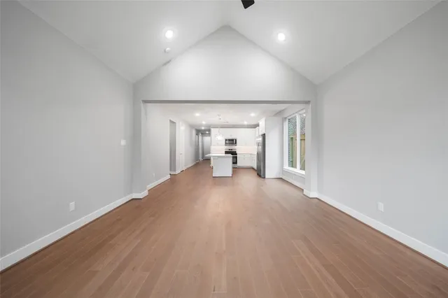 a view of a big room with wooden floor and windows