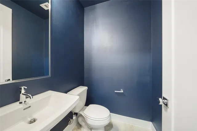 a bathroom with a sink a toilet and a mirror