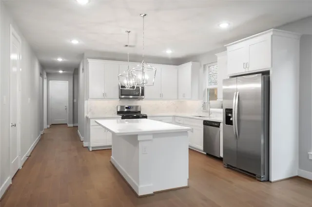 a kitchen with kitchen island a sink stainless steel appliances and cabinets