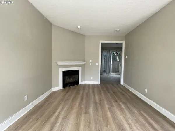 a view of an empty room with window and fire place
