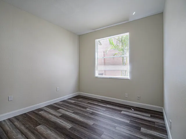 a view of an empty room with wooden floor