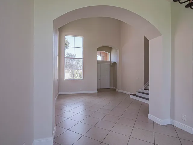 an empty room with windows and mirror