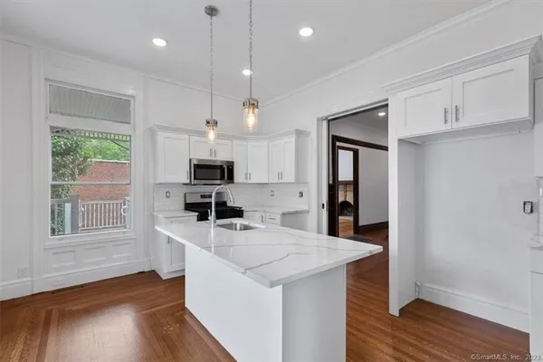 a kitchen with stainless steel appliances granite countertop a sink stove and refrigerator