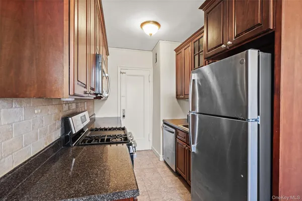 a kitchen with stainless steel appliances granite countertop a refrigerator and a stove