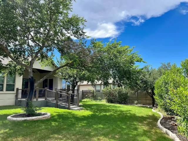 a view of a house with backyard and sitting area