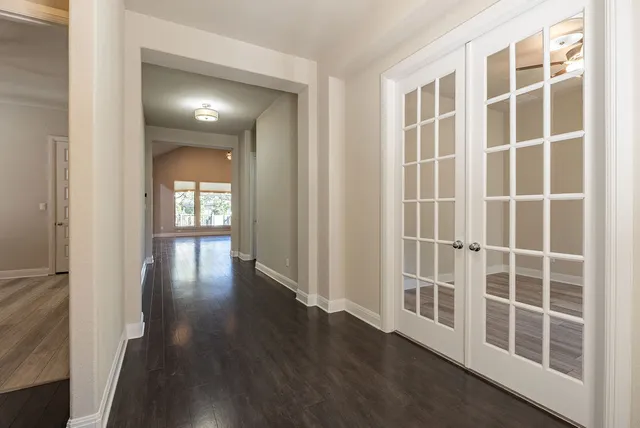 an empty room with wooden floor a fireplace and windows