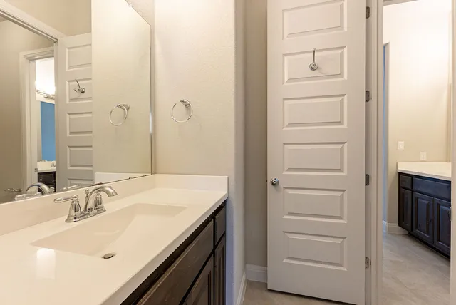 an empty room with wooden floor closet and windows