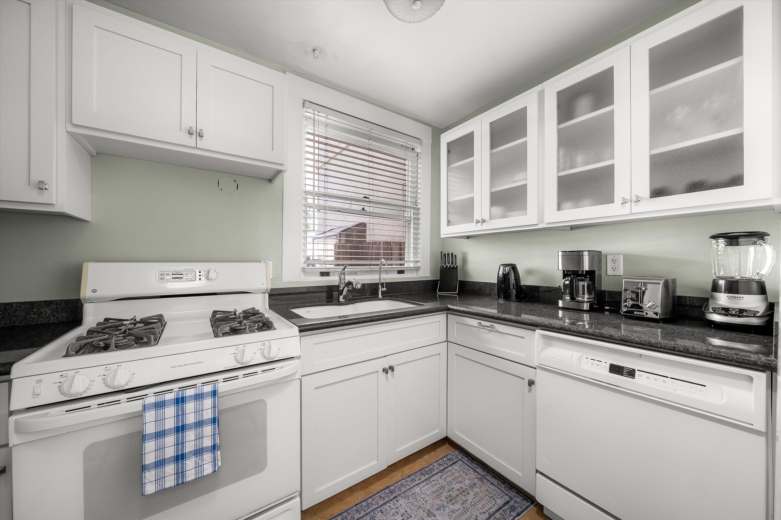 118 Chapala Street Santa Barbara, CA 93101 - Photo 22 of 46 a kitchen with stainless steel appliances granite countertop a stove a sink and white cabinets