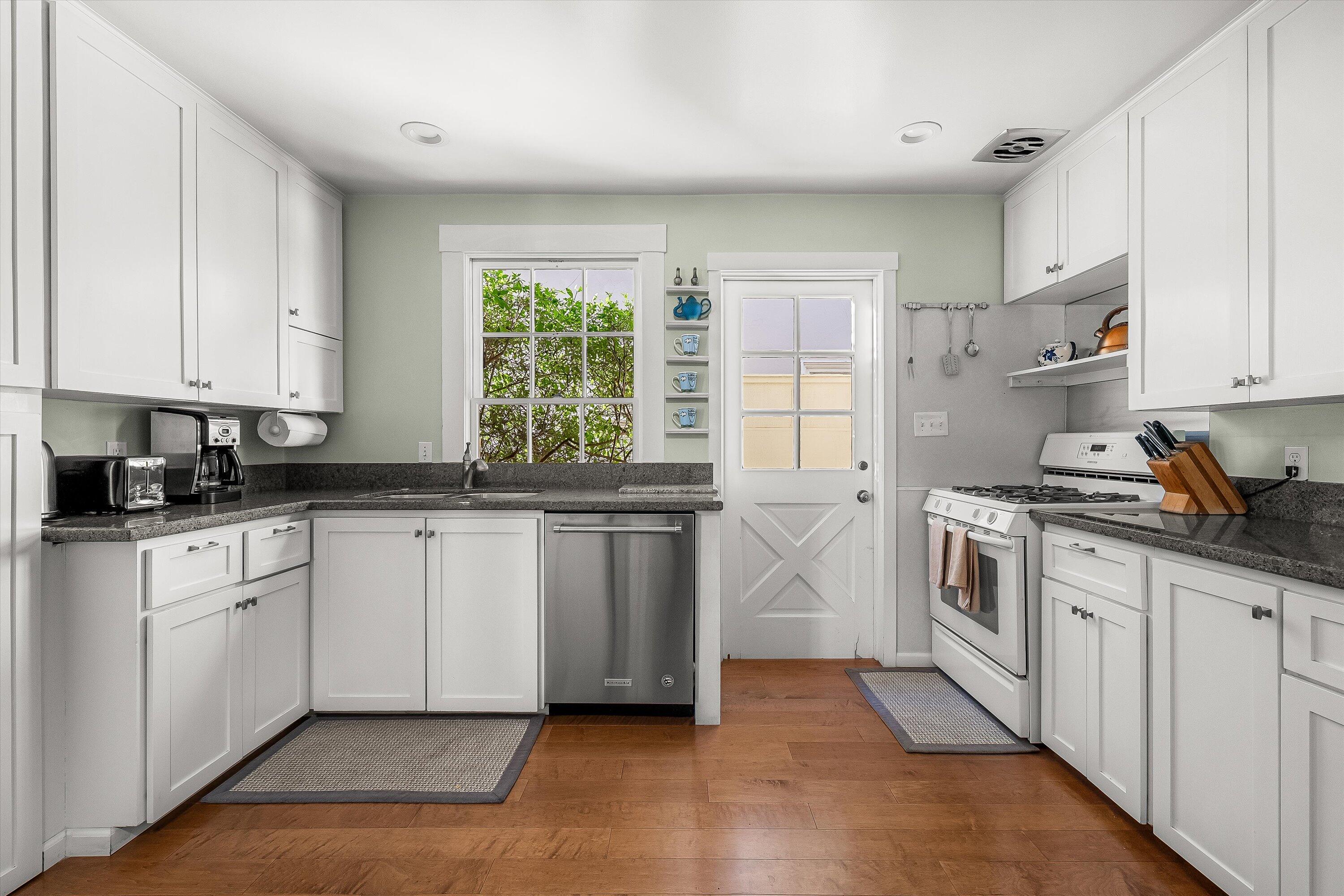 118 Chapala Street Santa Barbara, CA 93101 - Photo 6 of 46 a kitchen with granite countertop white cabinets and white appliances
