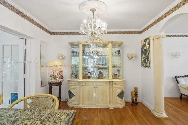 a view of a dining room with furniture a chandelier and wooden floor