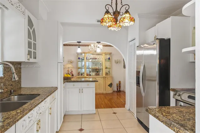 a kitchen with stainless steel appliances granite countertop a sink a refrigerator and a stove