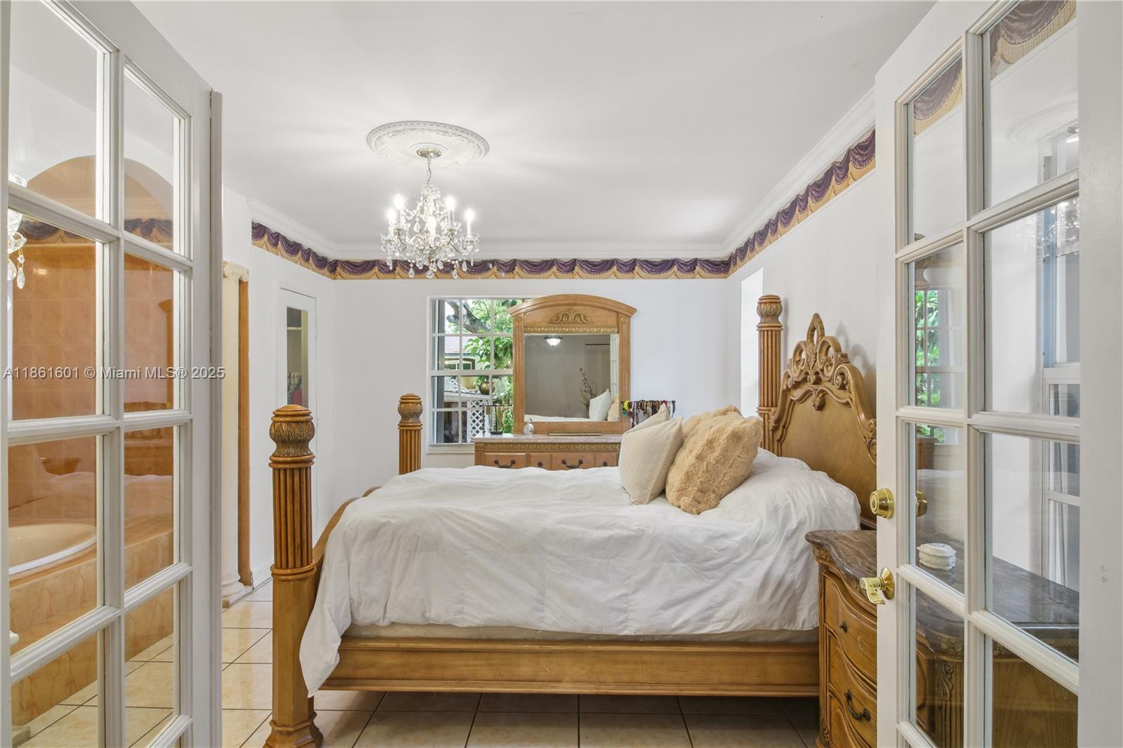 6101 Southwest 13th Terrace West Miami, FL 33144 - Photo 28 of 47 a bedroom with a bed window and chandelier