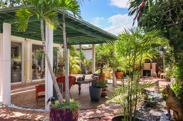 a view of a patio with table and chairs potted plants and palm trees