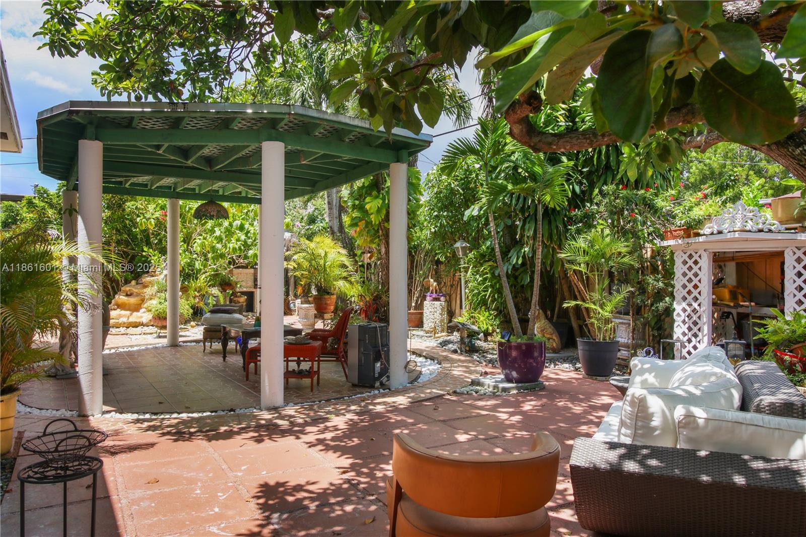6101 Southwest 13th Terrace West Miami, FL 33144 - Photo 35 of 47 a view of a patio with table and chairs potted plants and floor to ceiling window