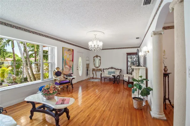 a living room with furniture and a chandelier