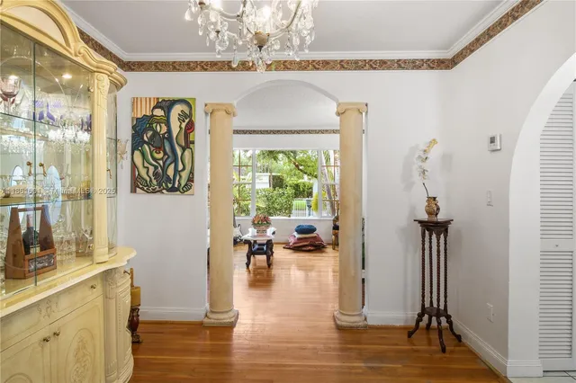 a hallway with a chandelier and wooden floor