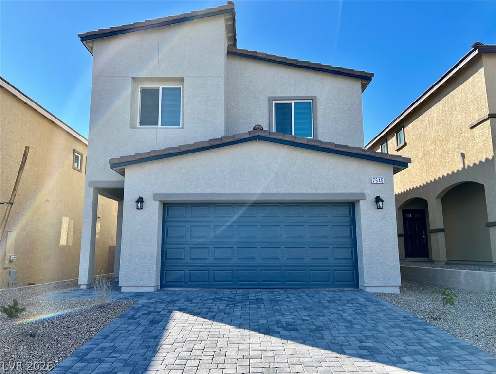 7845 Morganite Avenue Las Vegas, NV 89113 - Photo 1 of 21 A modern facade with a vibrant blue garage door complements the paver block driveway.