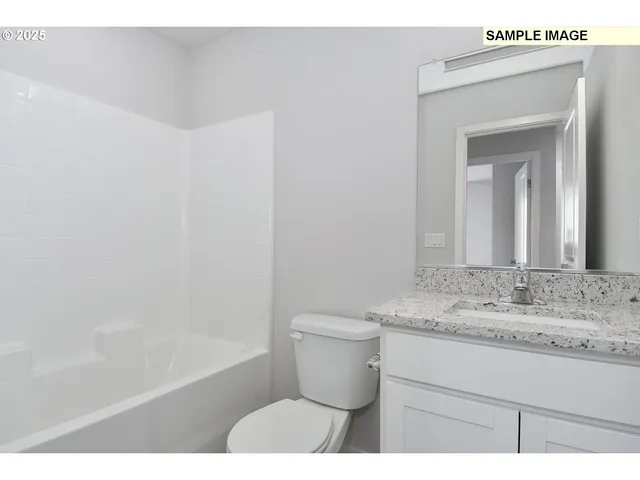 a bathroom with a granite countertop sink a toilet and bathtub