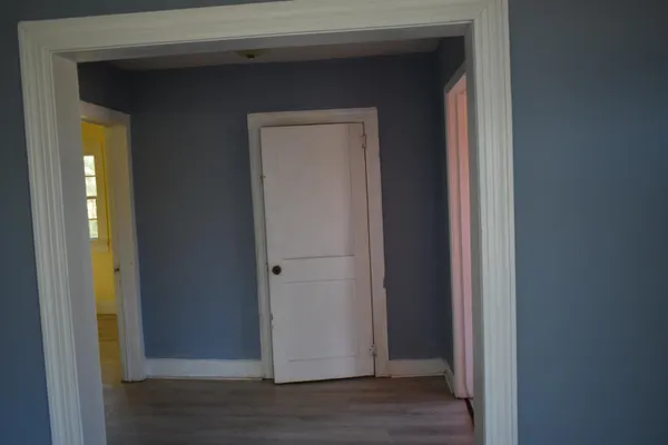 a view of a hallway with wooden floor