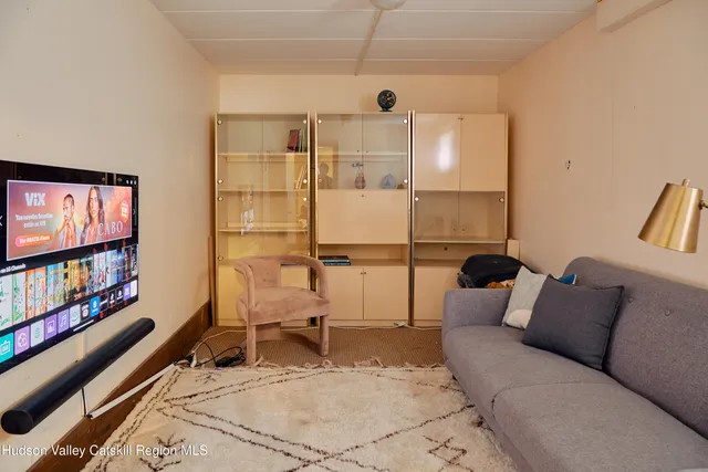 a view of a house with a yard plants and large tree