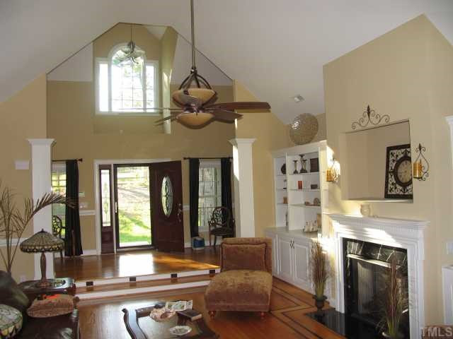 30 Piney Grove Road Bahama, NC 27503 - Photo 4 of 12 Living room with fireplace and built-in bookcases with view of mahogany front door, sidelights and palladium window. Living Room