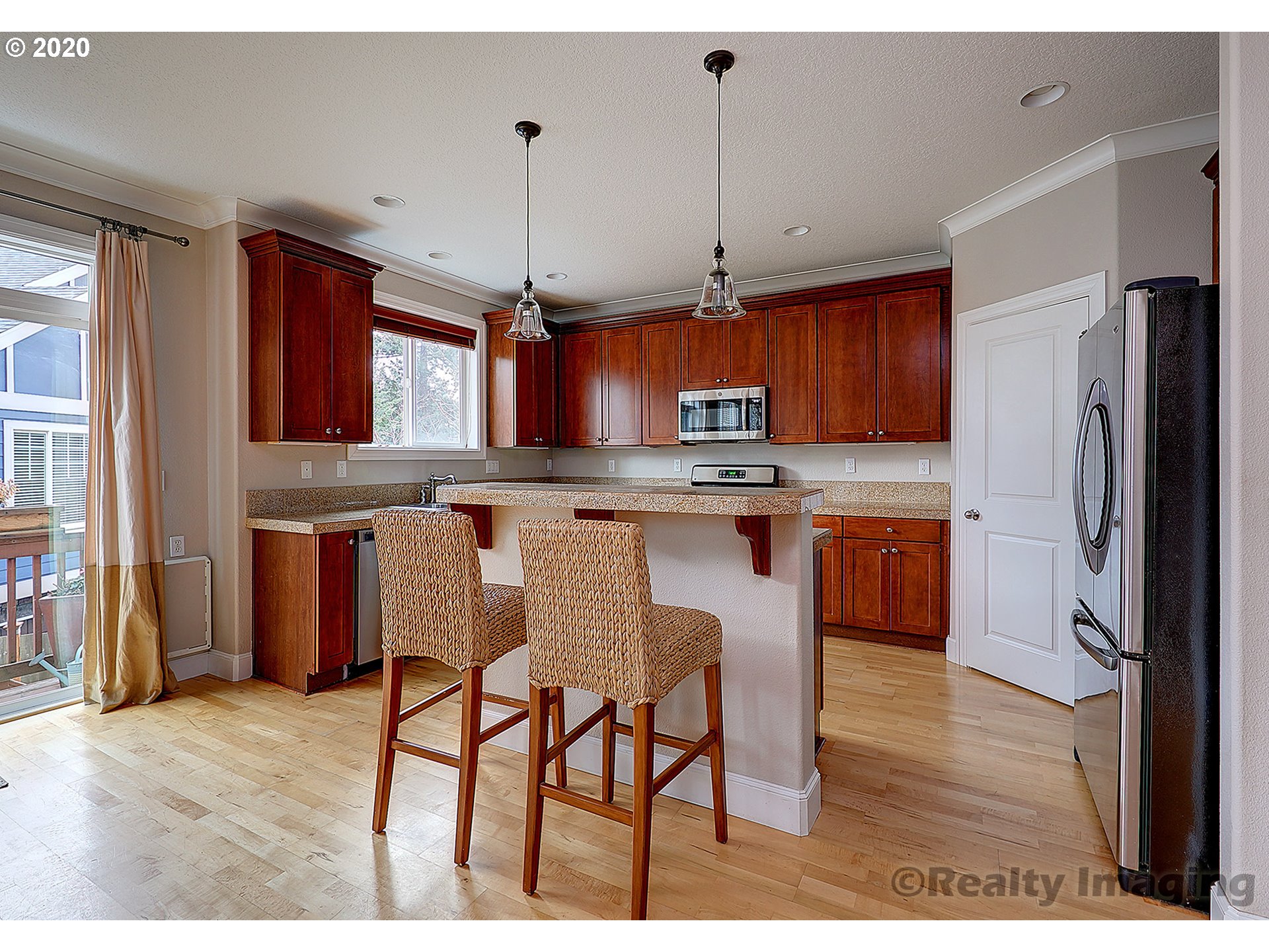 592 Southwest Elderbrook Place Portland, OR 97225 - Photo 11 of 30 a kitchen with stainless steel appliances granite countertop a refrigerator a sink dishwasher a stove and a dining table with wooden floor