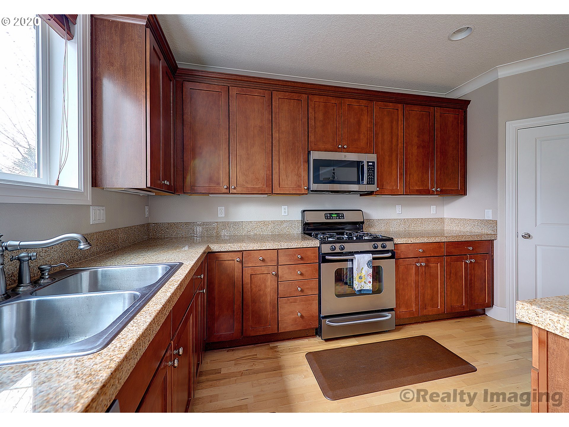 592 Southwest Elderbrook Place Portland, OR 97225 - Photo 14 of 30 a kitchen with stainless steel appliances granite countertop a stove a sink and a microwave