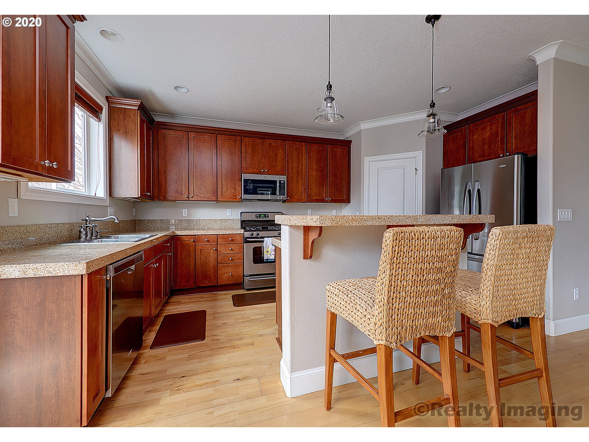 592 Southwest Elderbrook Place Portland, OR 97225 - Photo 10 of 30 a kitchen with stainless steel appliances granite countertop a stove top oven a sink a dining table and chairs