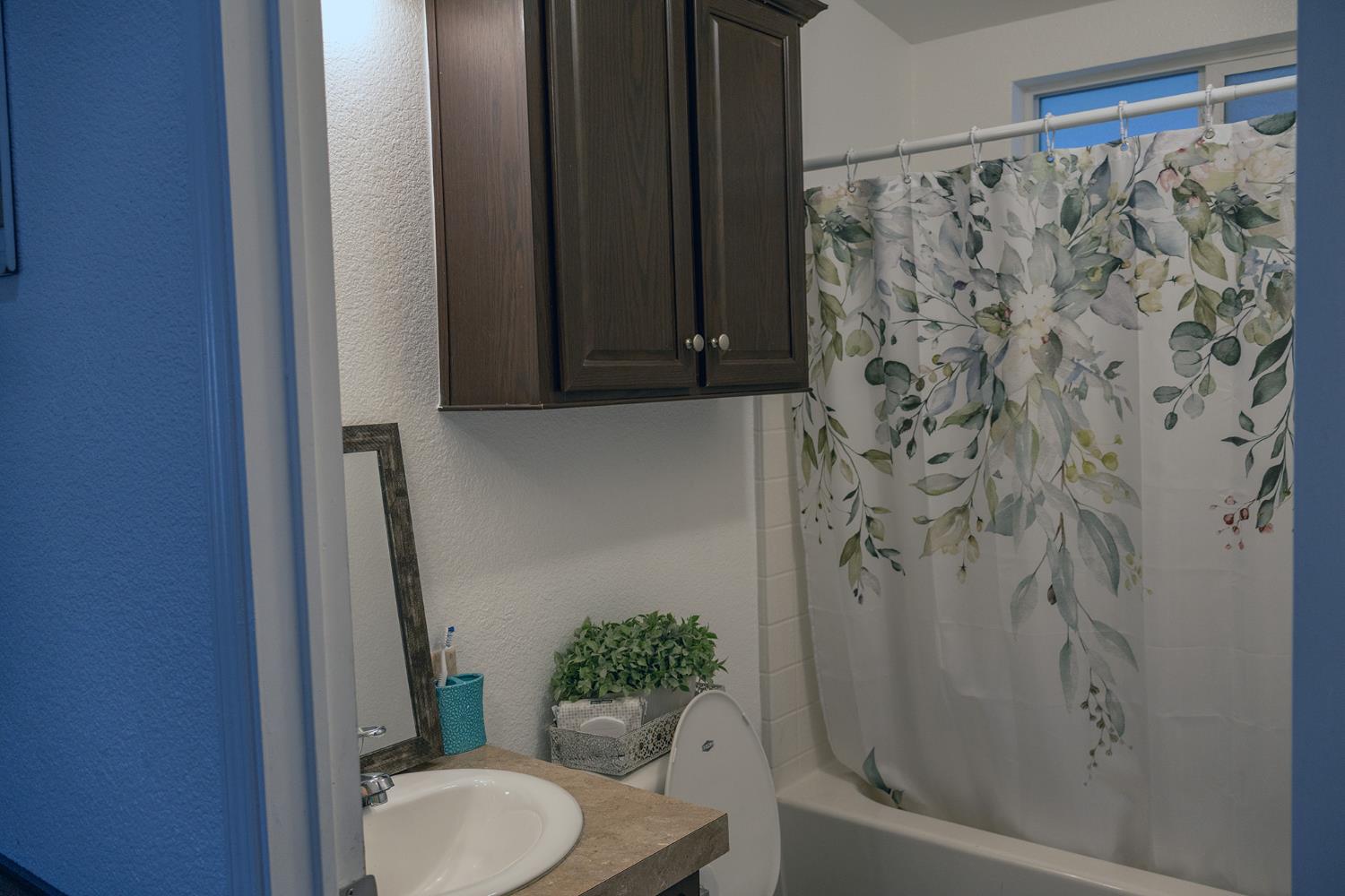 2499 East Gerard Avenue, Unit 123 Merced, CA 95341 - Photo 11 of 15 a bathroom with a shower curtain and toilet