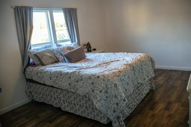 a bed sitting in a bedroom next to a window