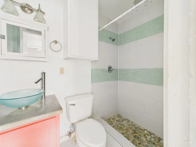 a bathroom with a granite countertop toilet sink and mirror
