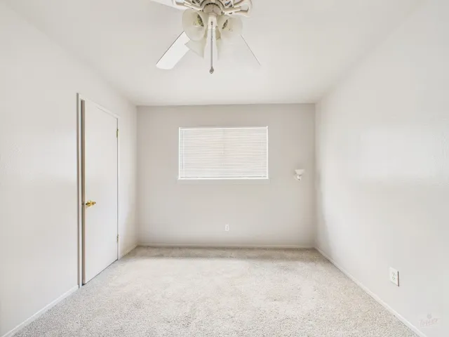 an empty room with a chandelier fan