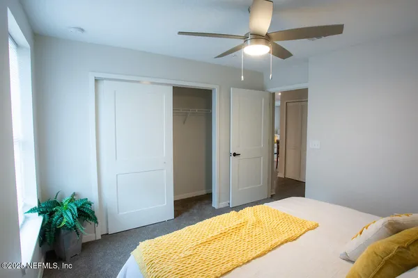 a bedroom with a bed and a potted plant